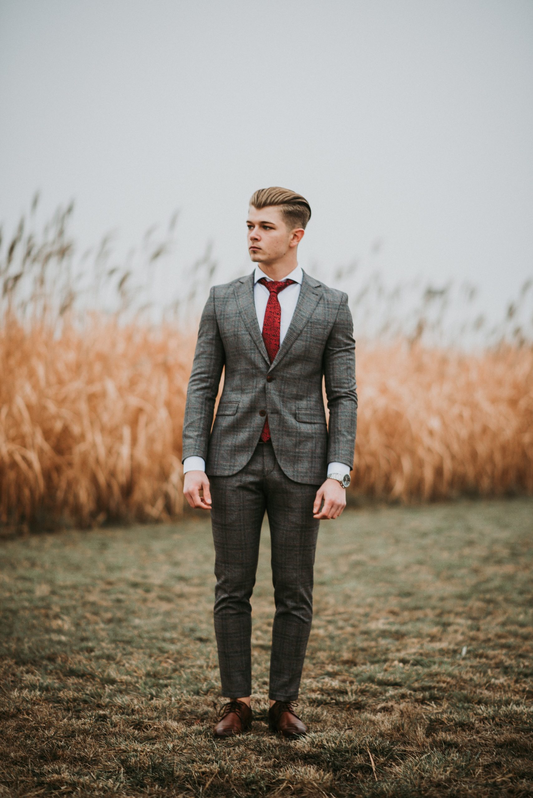 A man stands confidently in a suit altered by Rose N Silk, emphasizing the impact of professional alterations on appearance and self-assurance